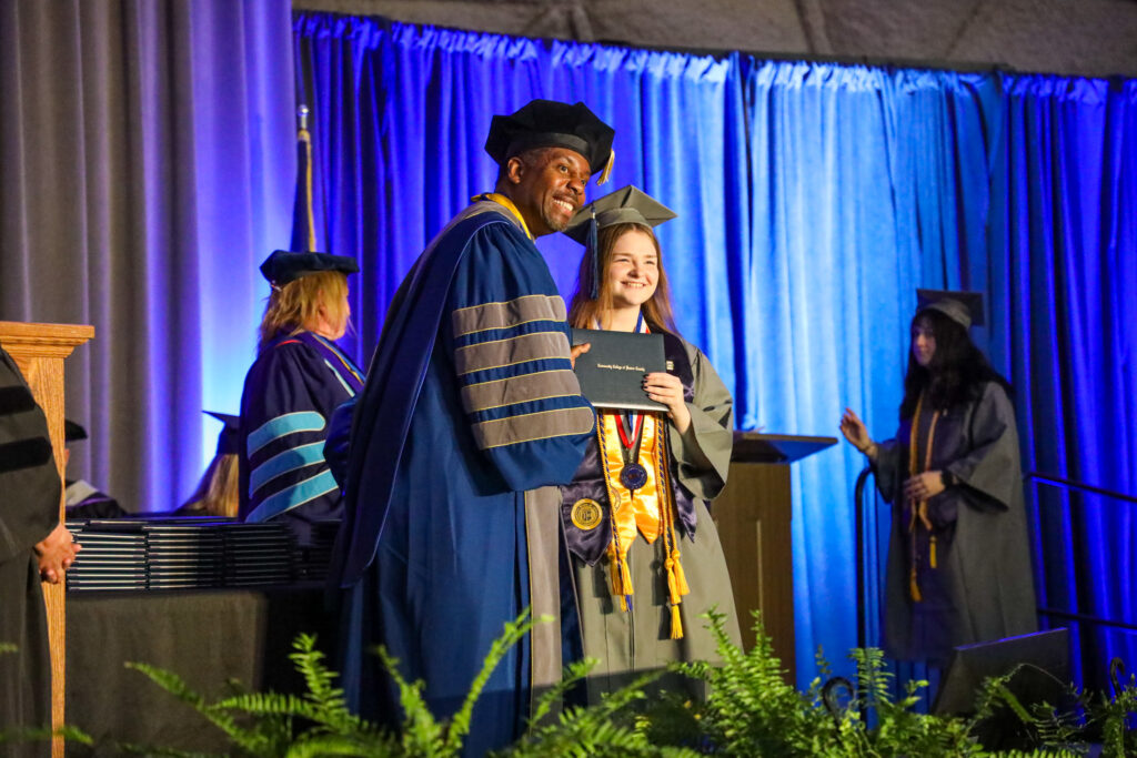 President of ccbc shaking hands and handing a diploma to a ccbc student